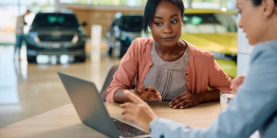 Salesperson showing a customer payment terms for a new car