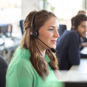 A Global Payments customer service representative takes a service call on her headset