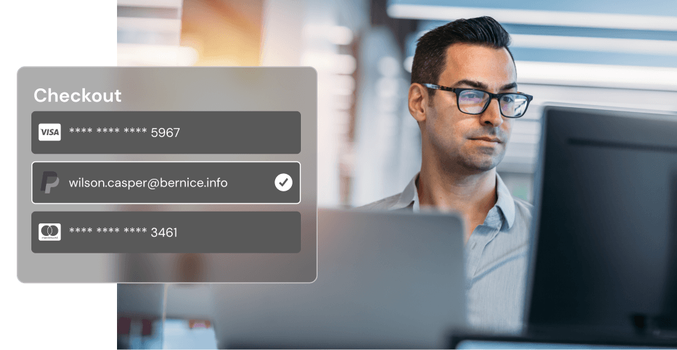 A man with glasses makes a payment on his computer. A pop up shows a secure credit card checkout.