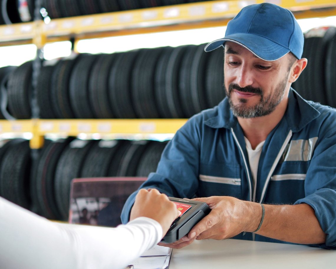 Tire salesperson taking a card payment on a POS