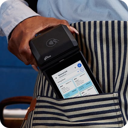 A handheld POS device in a bartender’s apron pocket.