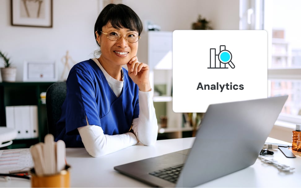 Healthcare worker smiling at desk with laptop and popup that says Analytics