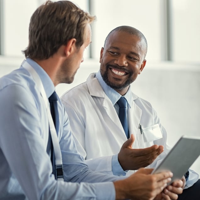 Two healthcare workers talking in an office environment