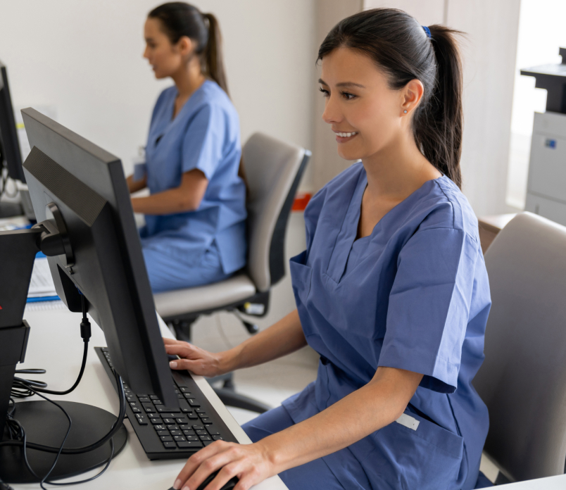 Healthcare worker sitting at desk working at computer in office