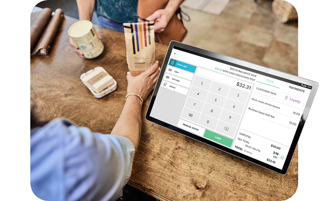 A countertop POS being used to sell a bag of coffee and a mug to a customer.