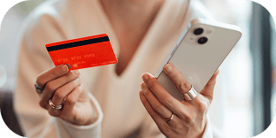 A person holding their credit card in one hand and their cell phone in the other.