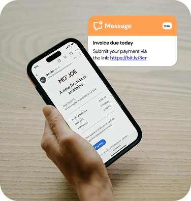 A phone displaying a text reminder that an invoice is due, along with a payment link.