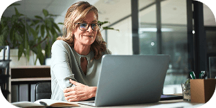 A person sitting at a desk in front of their laptop.