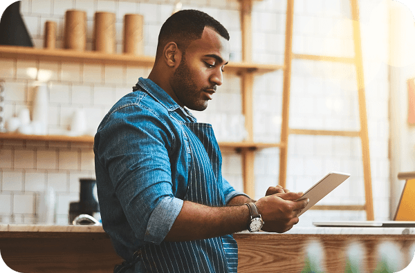 A restaurant owner checks his inventory from a mobile tablet.