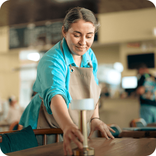 A restaurant staff member sets a table.