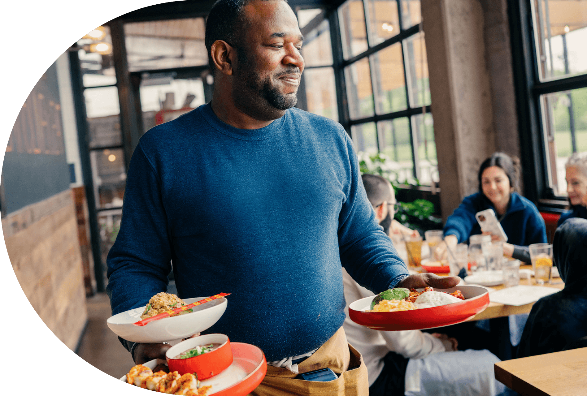 Waiter bringing food to table in restaurant