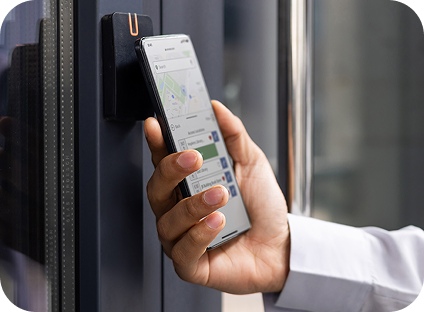 A person using a cell phone application to access a building on a college campus. 