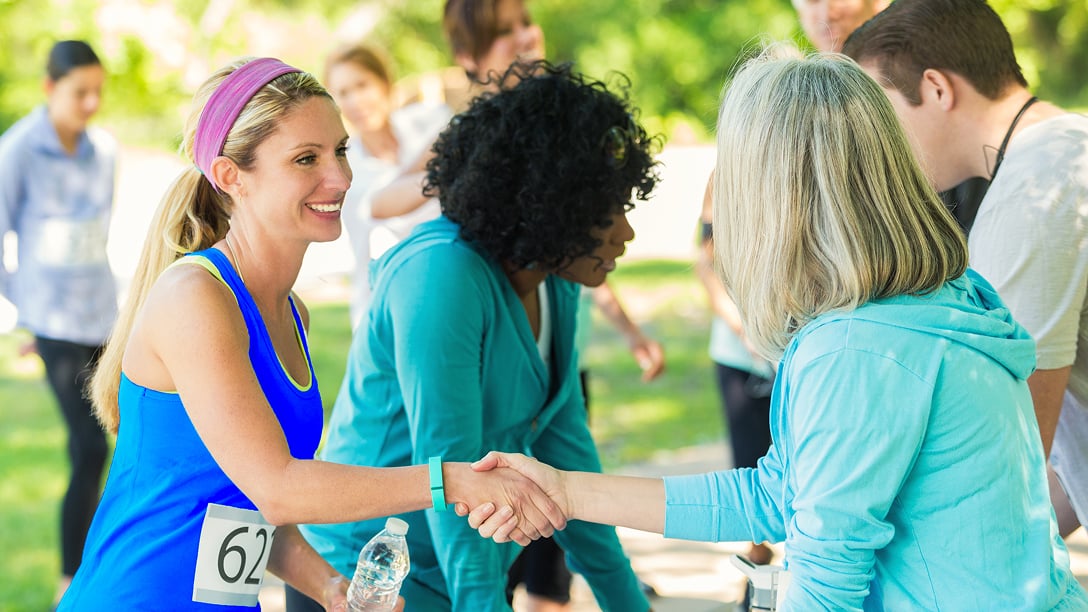 A marathon runner shaking hands with an organizer.