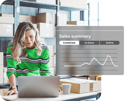 Small business owner in a stock room smiling at her laptop. A “Sales summary” screen with a sales chart is popping out.