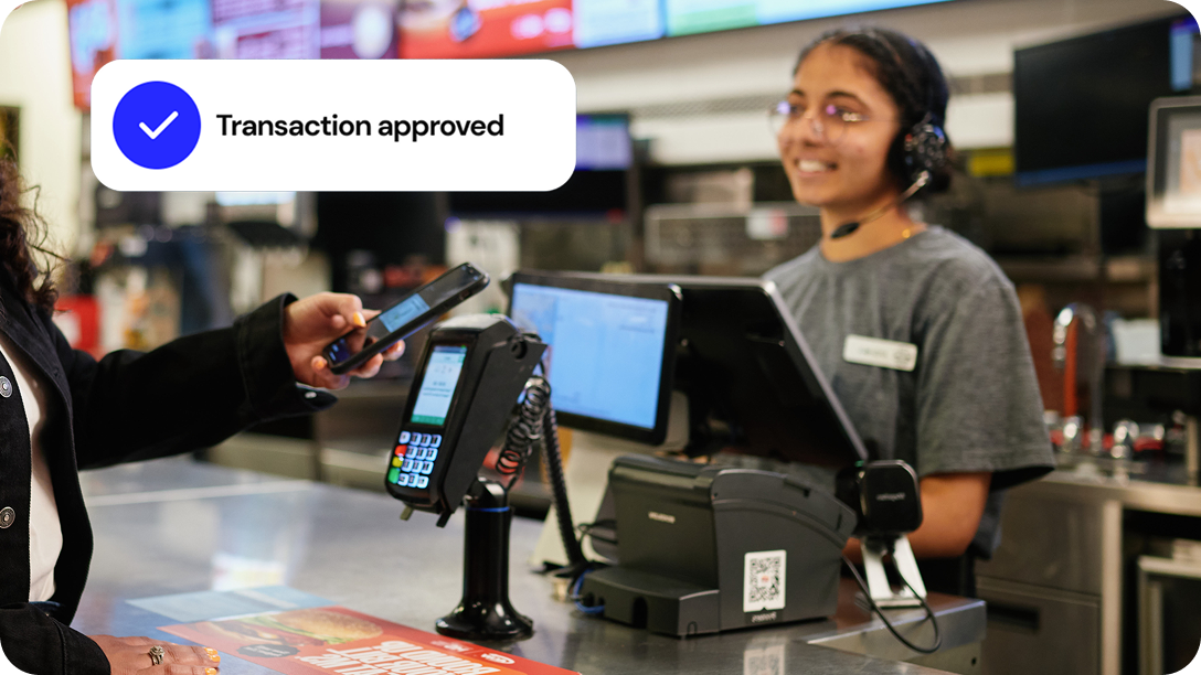 A server picks up a meal from the kitchen to deliver it to a customer.