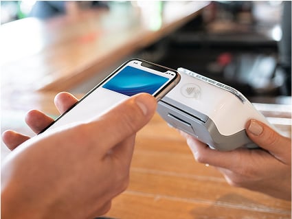A mobile phone makes a payment on a portable card machine.