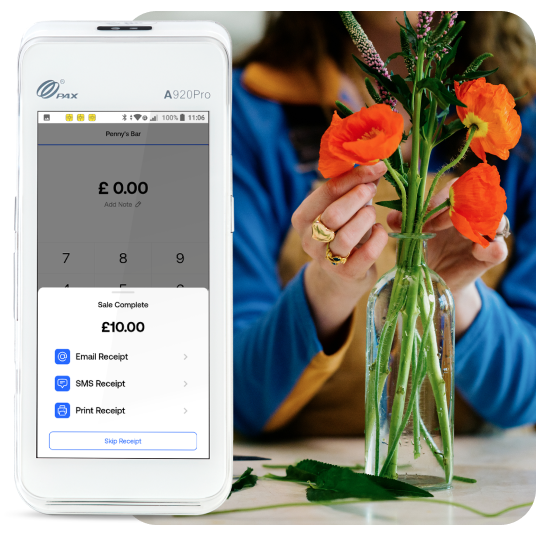 Woman arranges orange begonias in a glass vase next to a PAX A920 card machine.