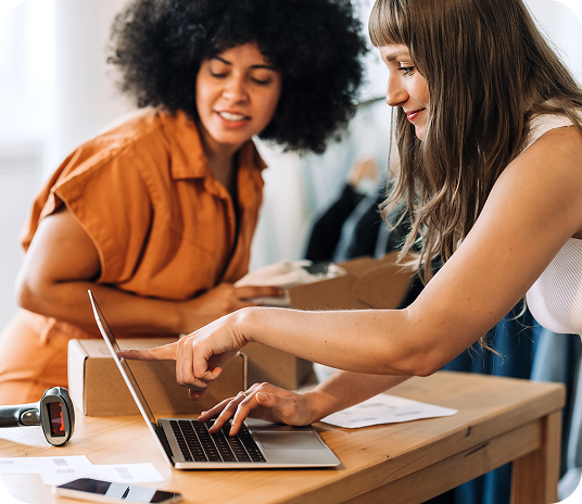 Two people working in a small business set up payment processing solution on laptop.
