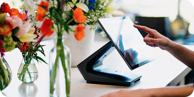 Worker uses countertop point of sale in retail shop. 