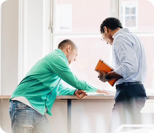 Two people discuss pricing options for payment processing.