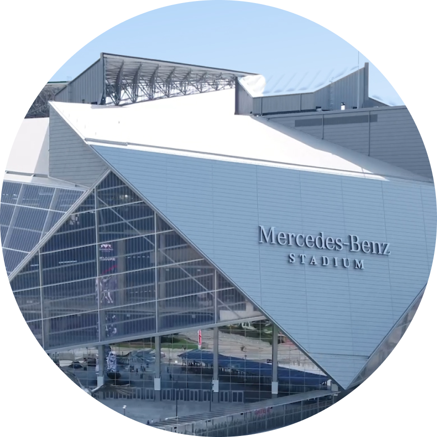 Circular image showing exterior facade and distinctive angular roofline of Mercedes-Benz Stadium in Atlanta, Georgia