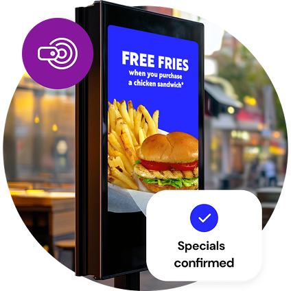 A freestanding, outdoor digital menu board shows a free fries special, while a small, purple circle graphic with a pricing icon overlays the image at the top and a graphic reading “Specials confirmed” overlays the bottom of the image.