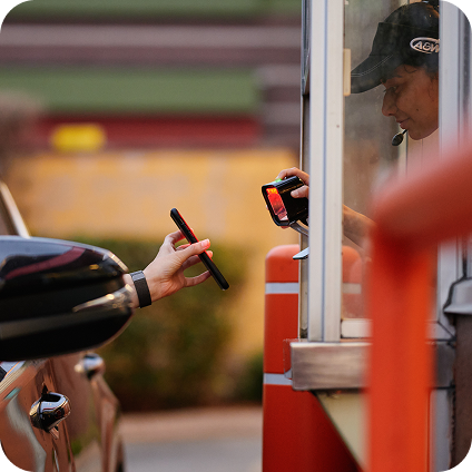 A customer receiving her order through her car window.