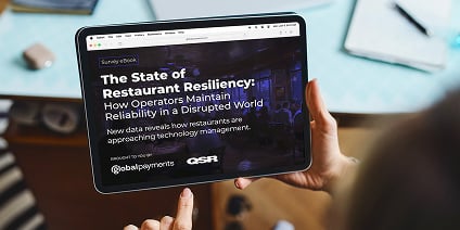 Person holding a tablet displaying a dark-themed QSR report cover titled “The State of Restaurant Resiliency.”