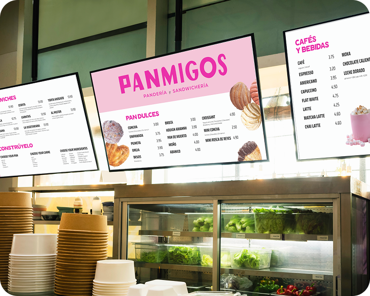 Large digital menu boards sit above the food prep station of a restaurant.