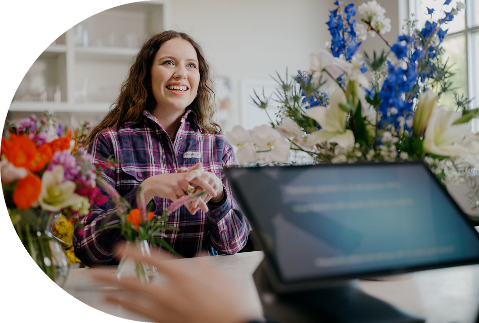 An employee looks up at her manager, who’s overseeing the point of sale system.