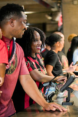 Soccer fans for Atlanta United make a payment at a countertop device.