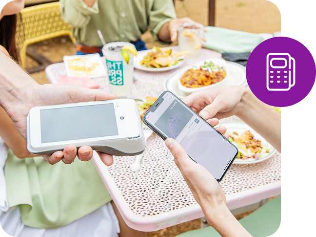 A mobile phone makes a tableside payment on a card reader.