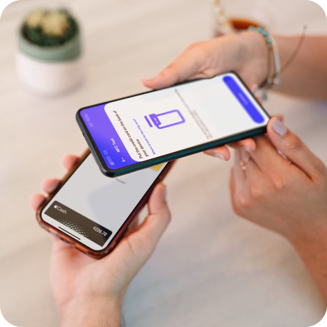 An iPhone is tapped against an Android phone to make a contactless payment