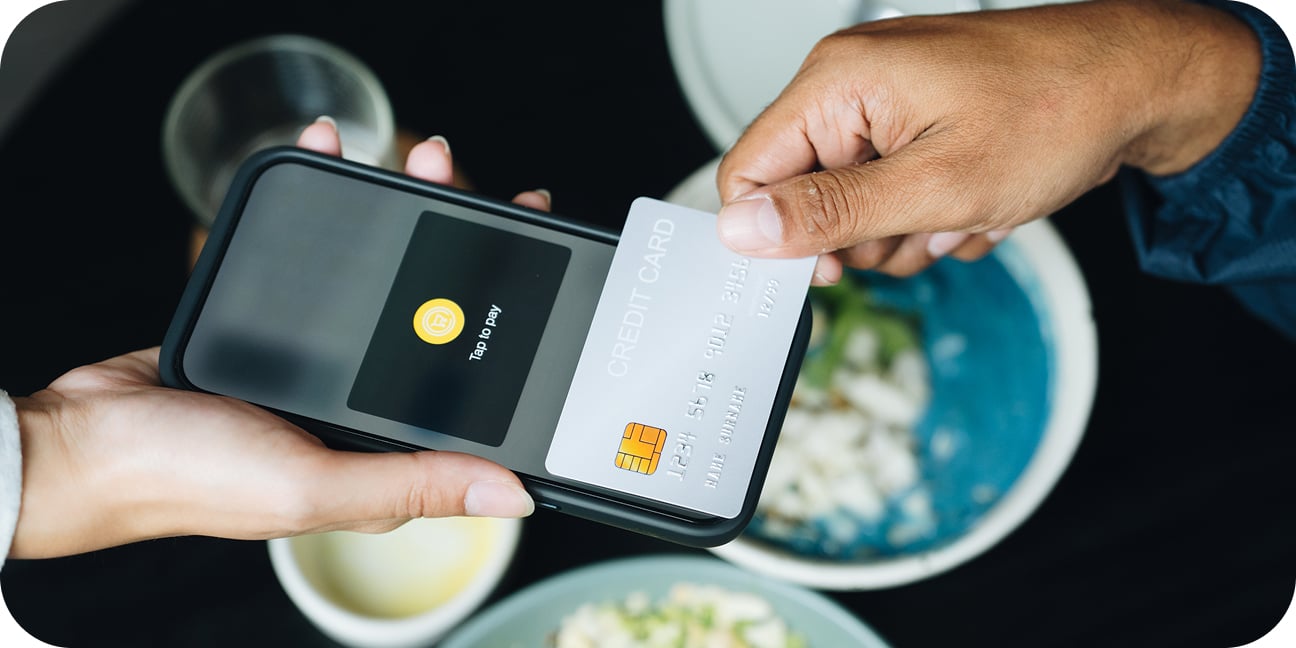 An iPhone is tapped against an Android phone to make a contactless payment