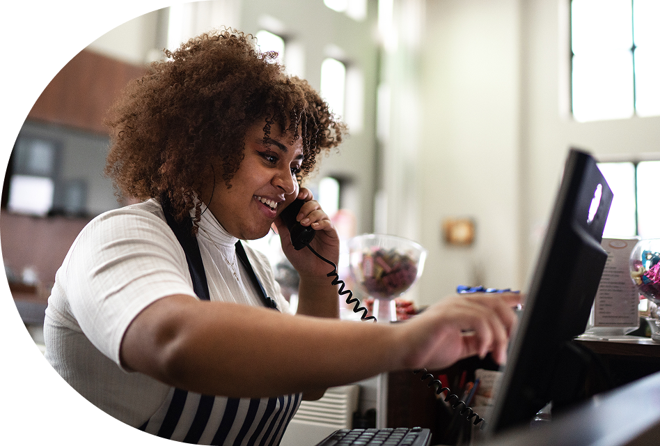 A barista takes a phone call while she’s making a coffee.