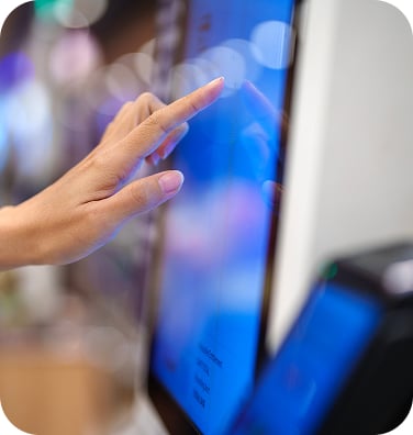 An up-close image of a hand using a touchscreen point of sale to make grab-and-go selections.