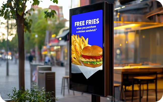 An image of an outdoor digital menu board displaying an offer for free fries.