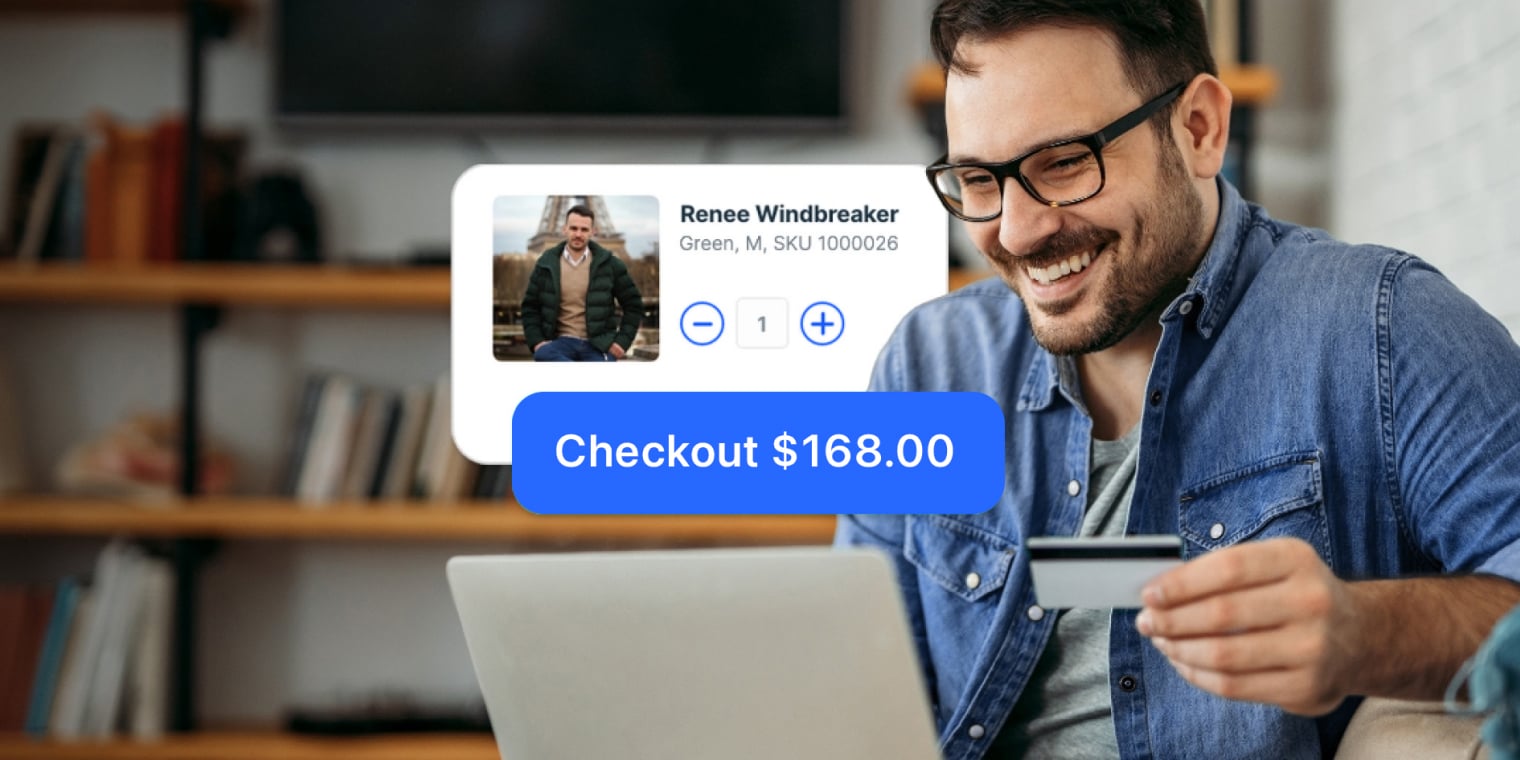 Person smiling while using laptop and holding credit card to complete online checkout for windbreaker