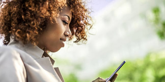 Close-up of young woman outside looking at mobile phone