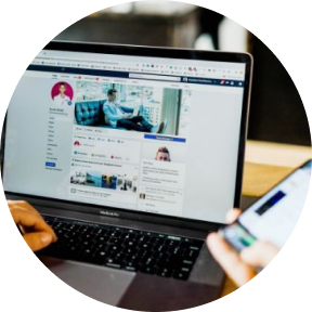 Close-up of person using laptop and mobile phone at the same time.