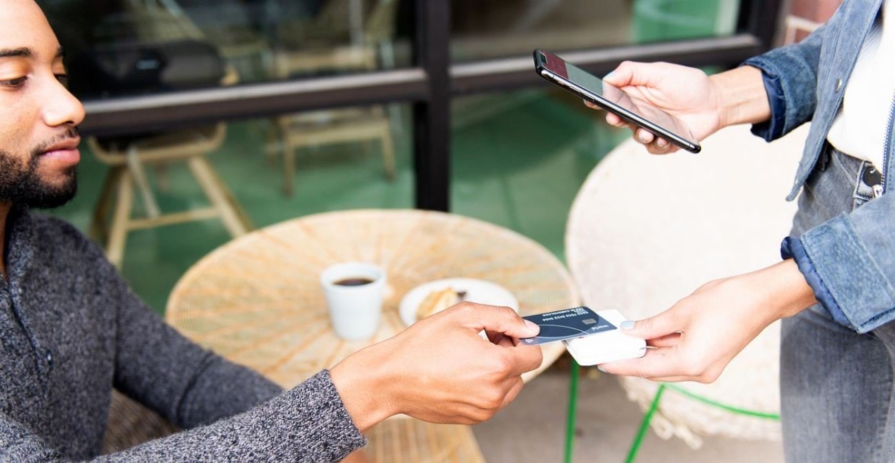 Customer in cafe uses credit card to pay on mobile POS system