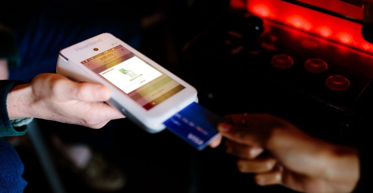 Close-up of payment card being inserted into handheld point of sale device
