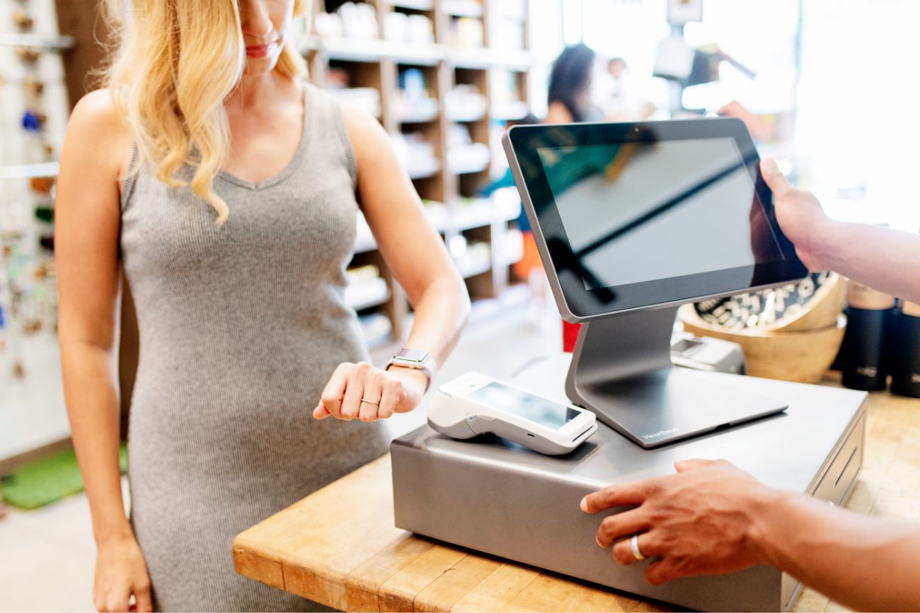 Customer in retail setting uses smartwatch to make payment at point of sale system