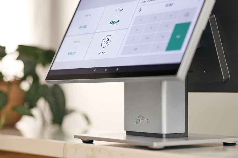Close-up of point of sale terminal on countertop in salon setting with potted plant in background
