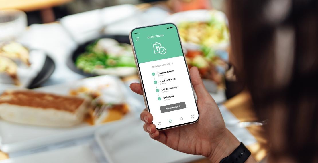 Smartphone displaying standard food-delivery tracking interface with order status updates