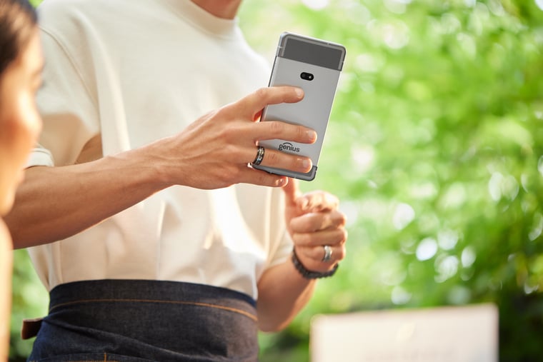 Close-up of server holding portable order-taking device at outdoor restaurant table in patio