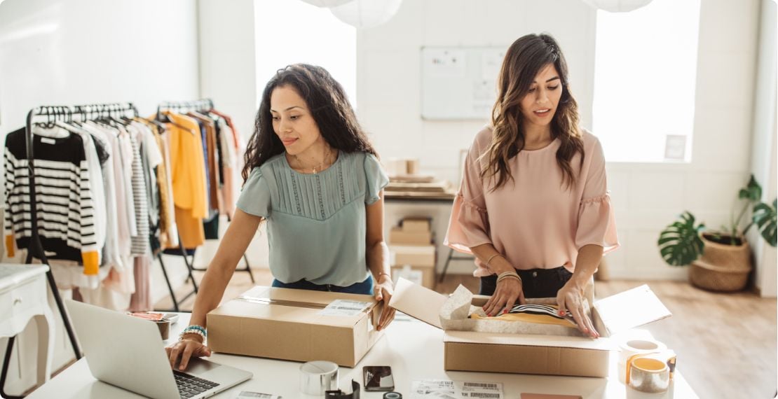 Two women preparing packages for shipping