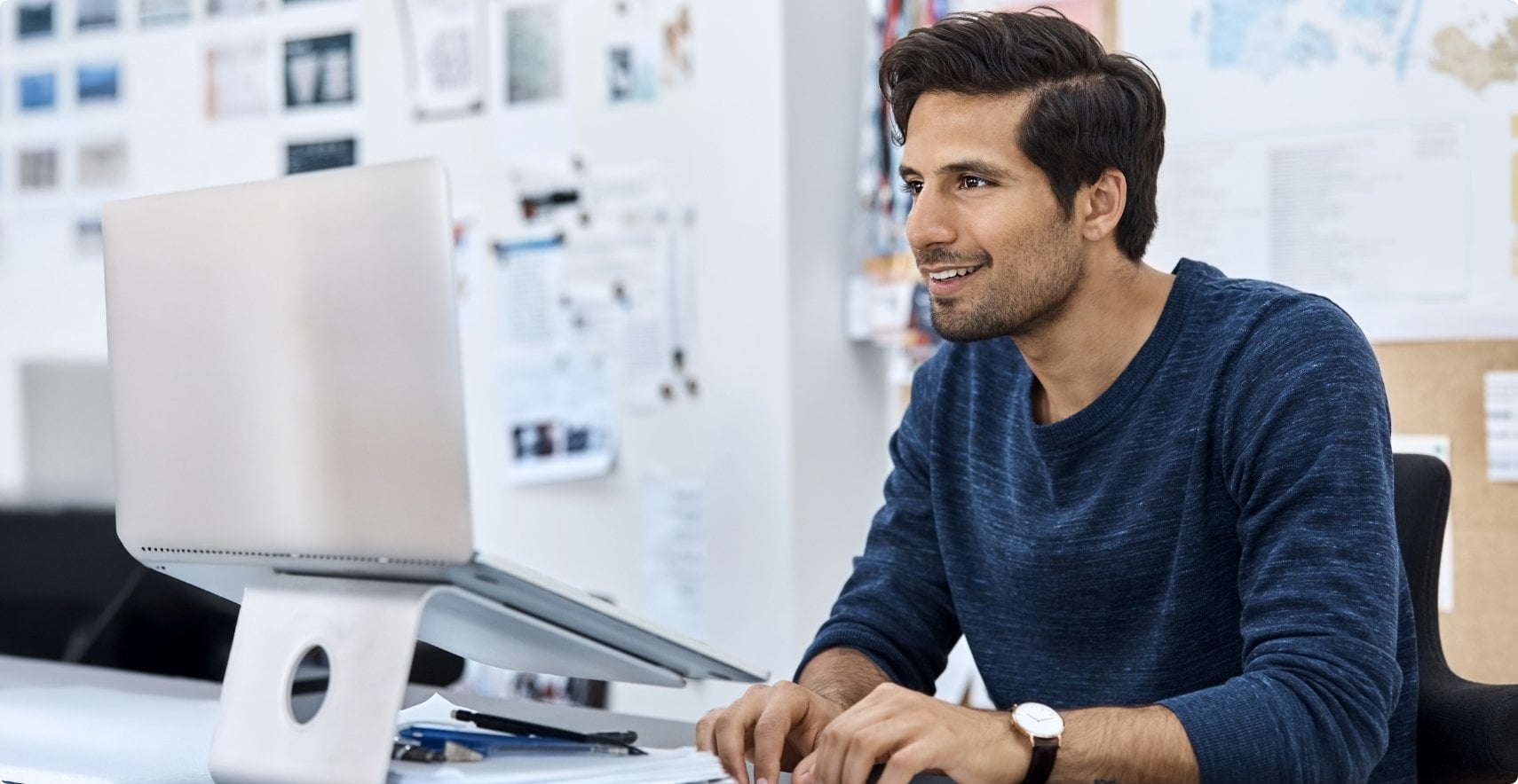 Seated ISV partner types on remote keyboard at elevated laptop