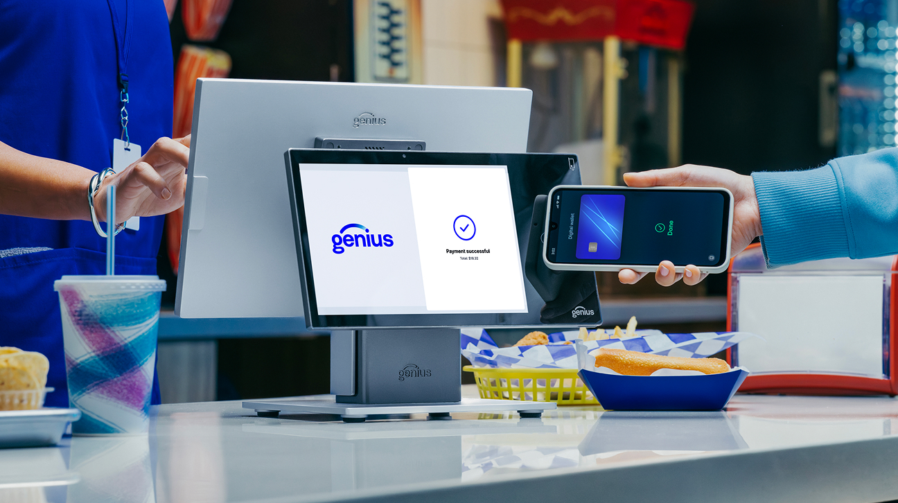Person in a quick-service restaurant holds up a smartphone to Genius countertop POS to make a contactless payment. 