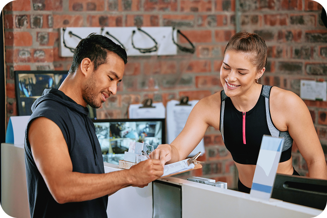 Man signs waiver while checking in at gym. 